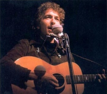 Dylan on stage with an accoustic guitar